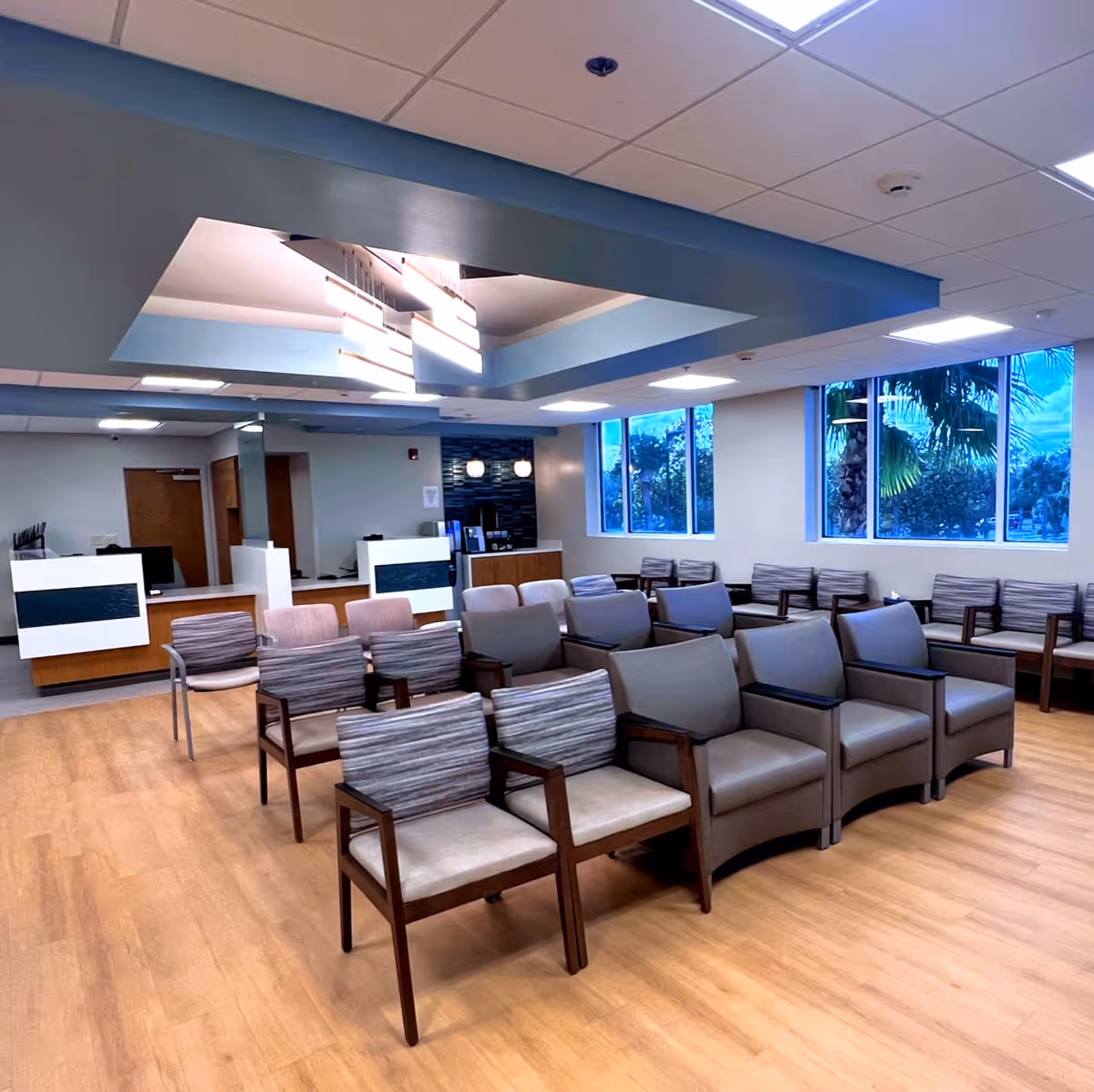 Bright waiting area with rows of chairs and large windowed wall.