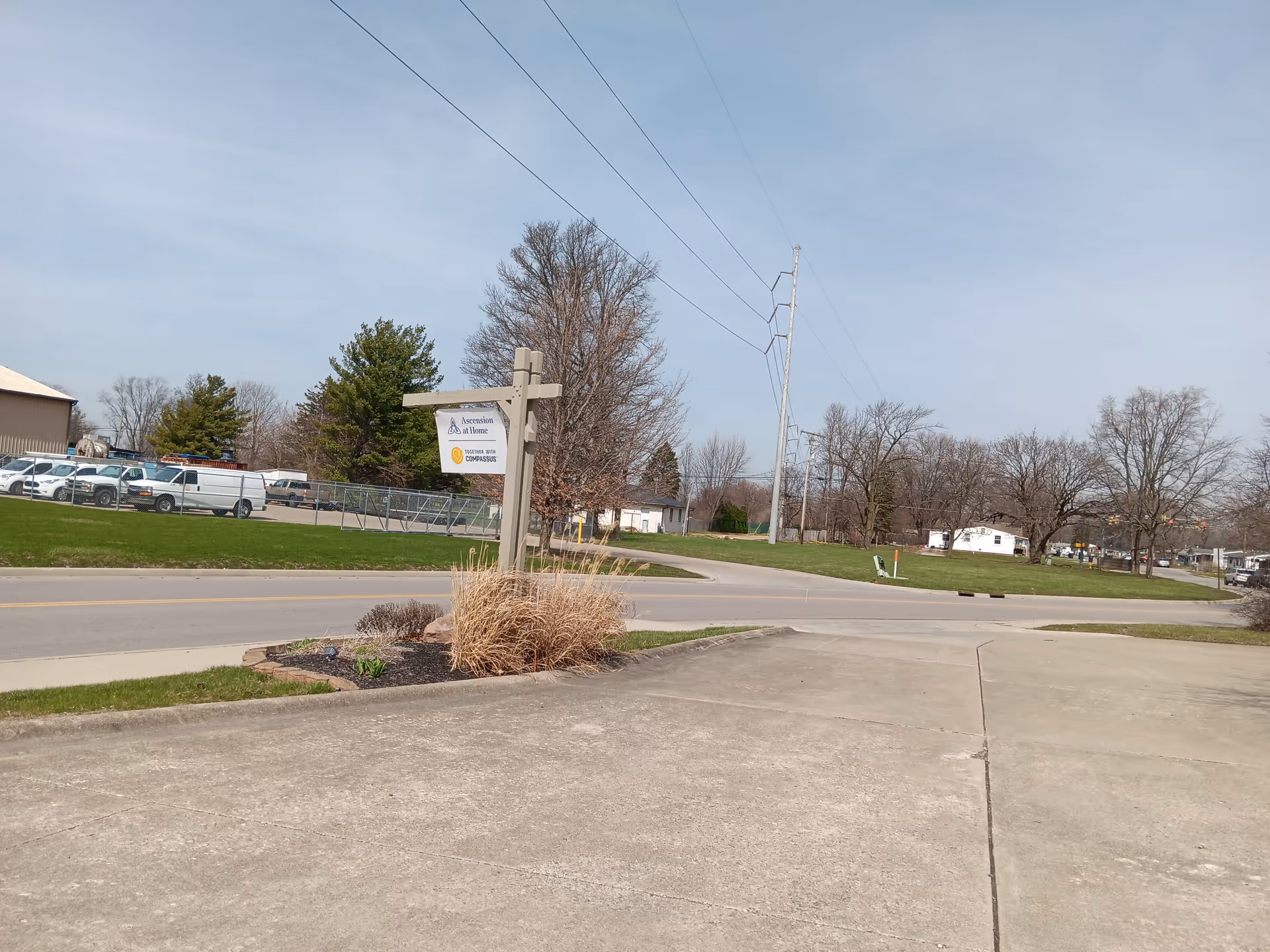 Wide outdoor view of a facility entrance with sign and surrounding parking lot.