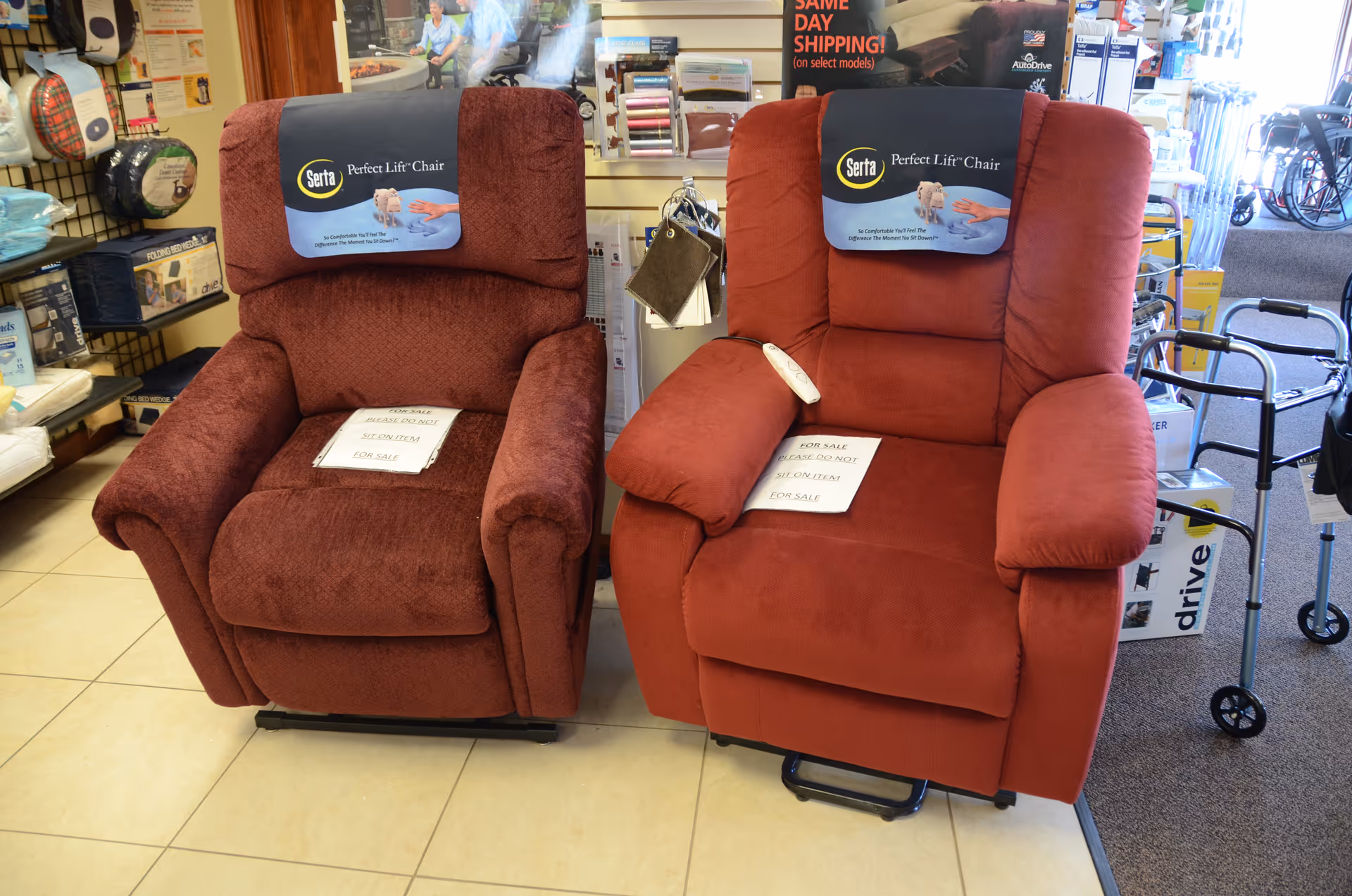 Two red recliner chairs on display in a store showroom.