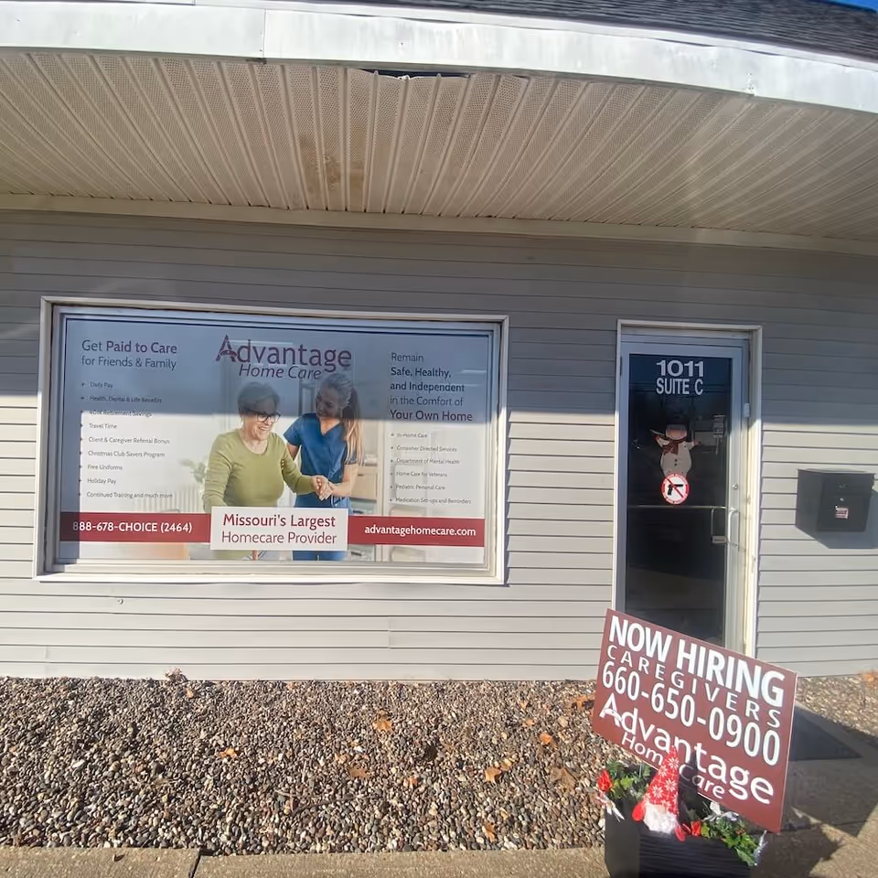 Exterior front of Advantage Home Care building with window sign and now hiring sign