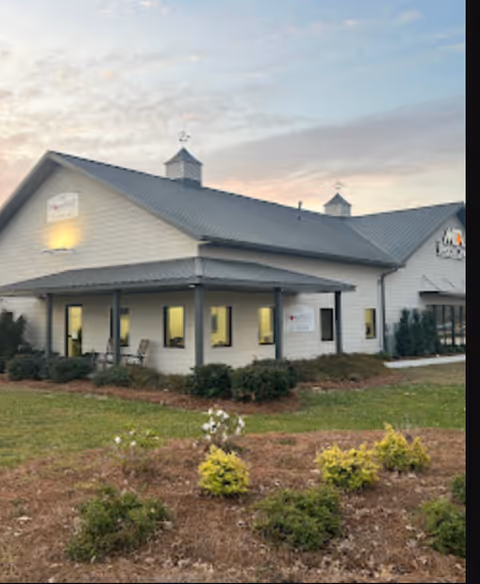Exterior view of a single-story senior care facility with a covered entrance and landscaping.