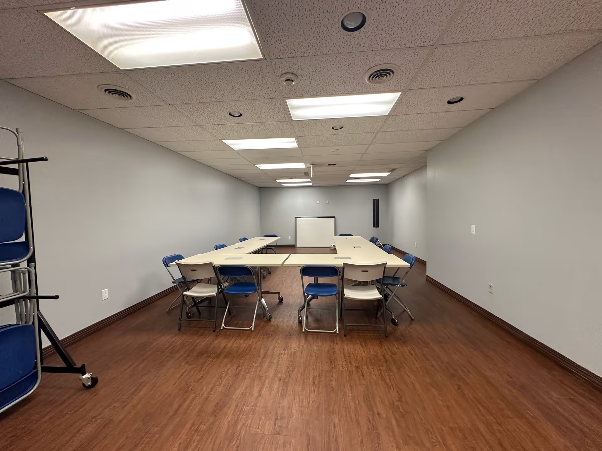 A long rectangular conference room with folding chairs arranged around a U-shaped table.