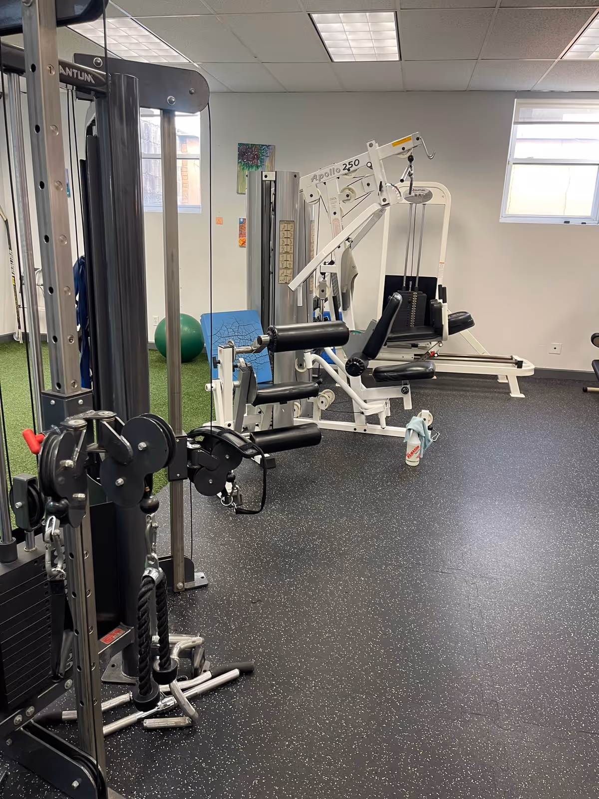 Indoor gym with weight machines and cables in a senior facility.