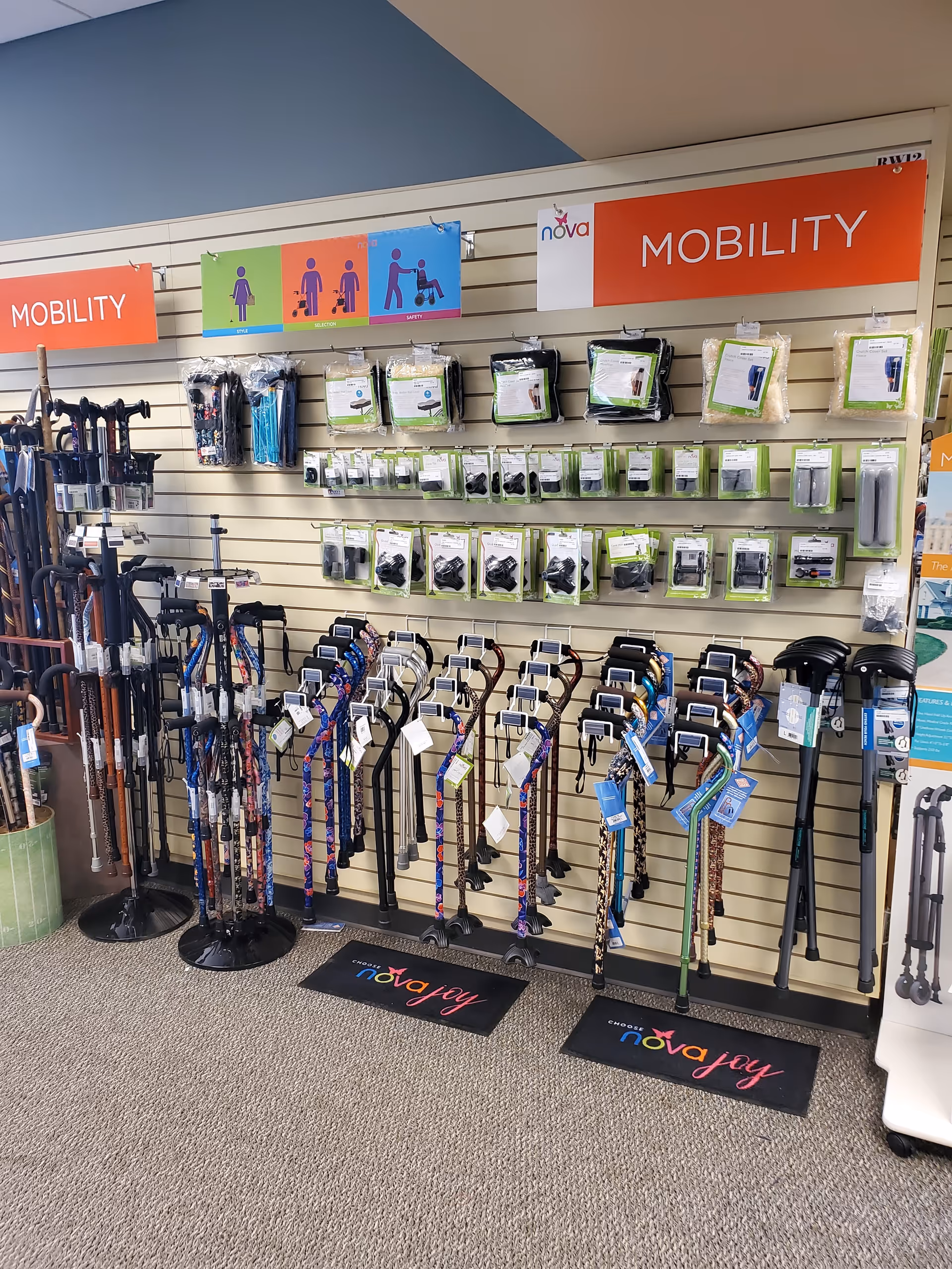Interior display of mobility aids (walkers and canes) on slatwall in a shop-like setting.