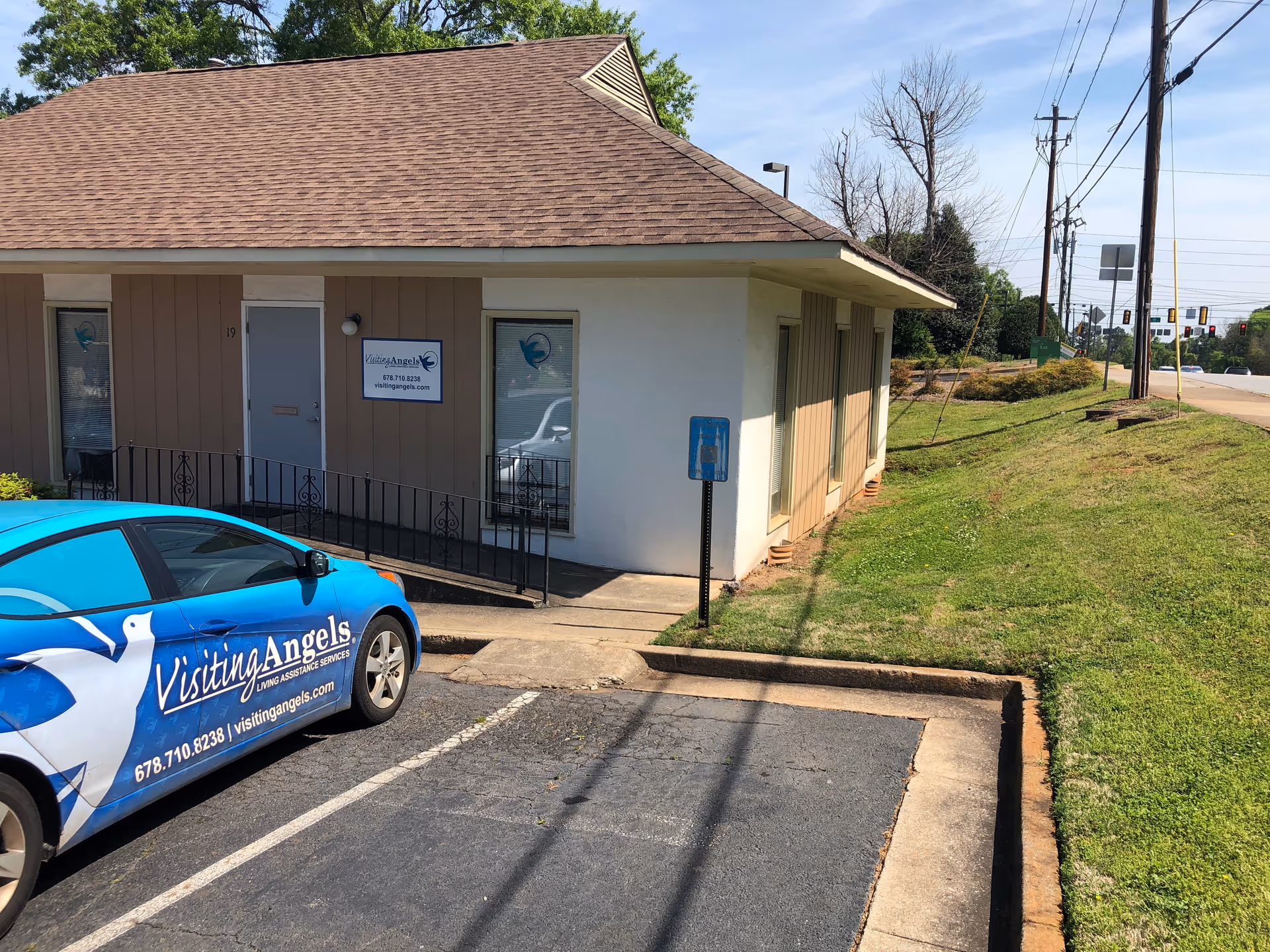 Exterior view of Visiting Angels building with a branded blue car in the parking lot.