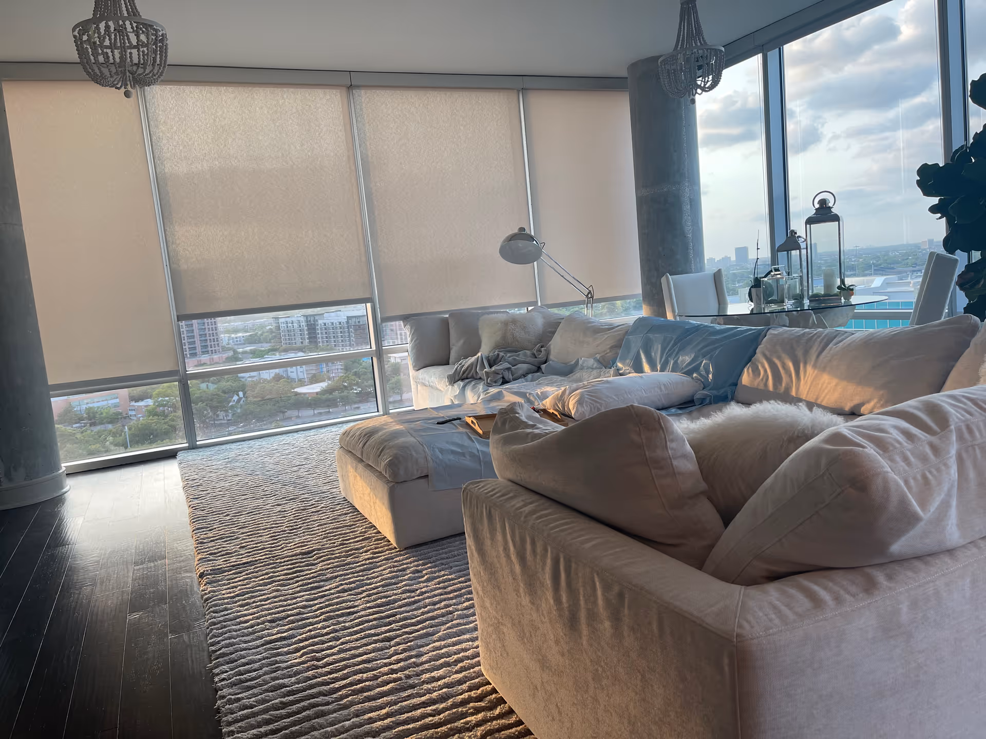 Spacious modern living area with white couches and large windows offering city views