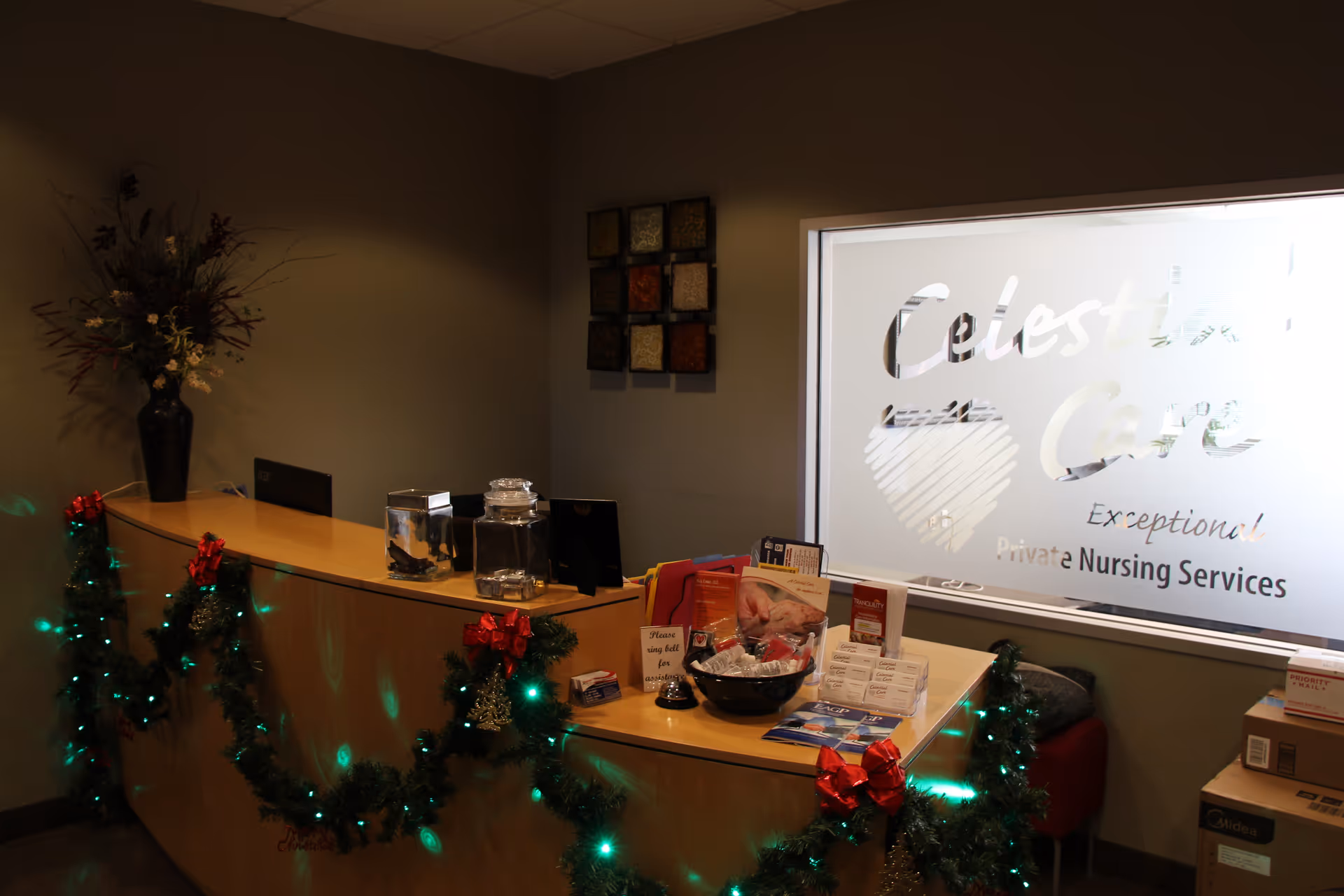 Reception desk with garlands and holiday decorations; frosted window reads Celestial Care Private Nursing Services.