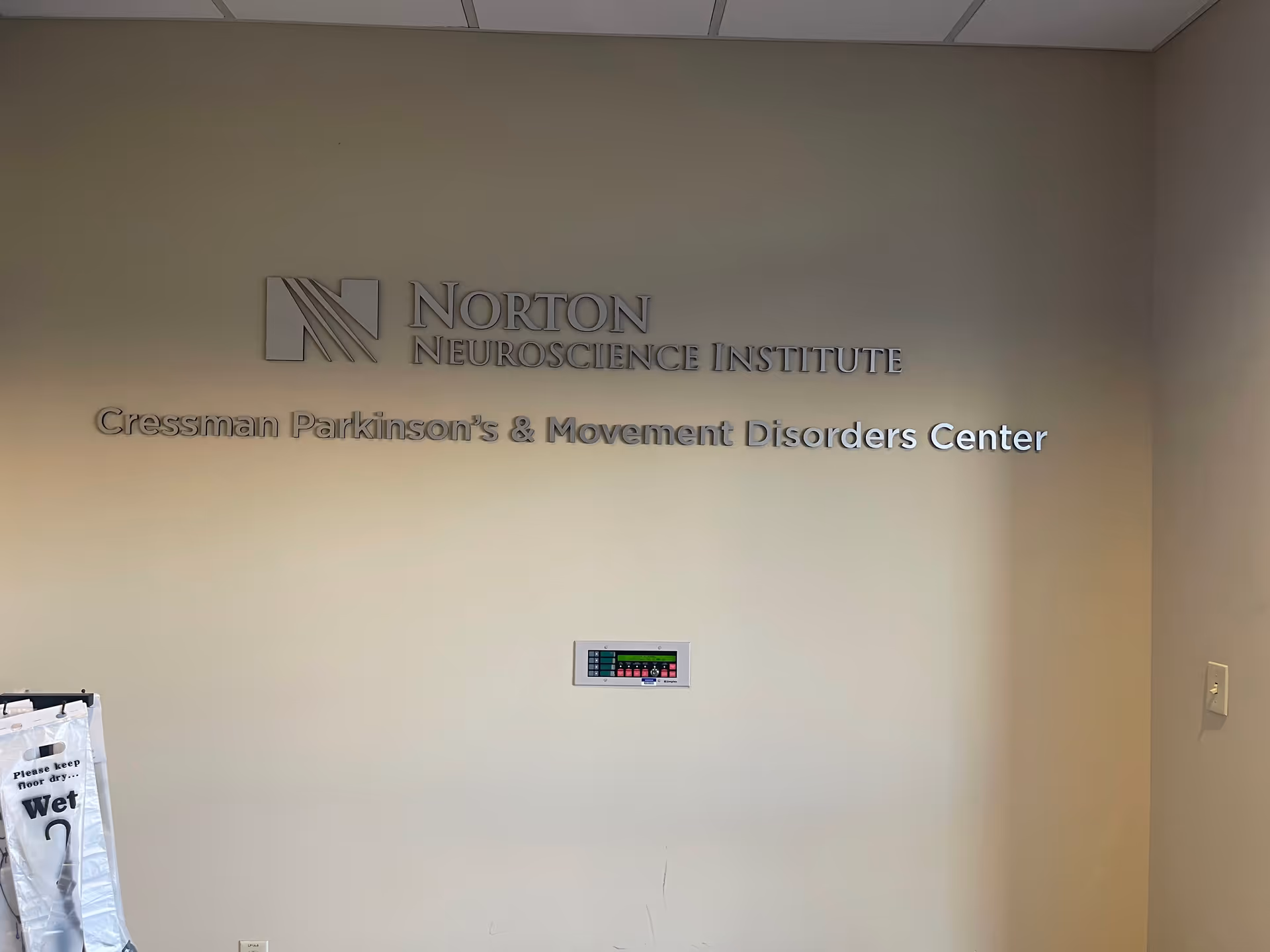 A Norton Neuroscience Institute sign on a beige wall inside Norton Healthcare Medical Plaza III.