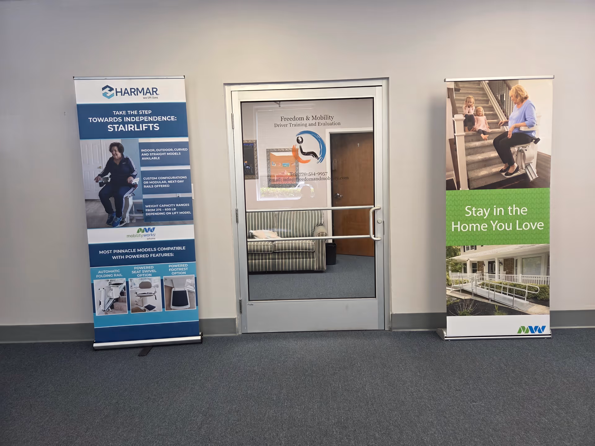 Hallway with two mobility banners beside a glass door in a MobilityWorks facility.