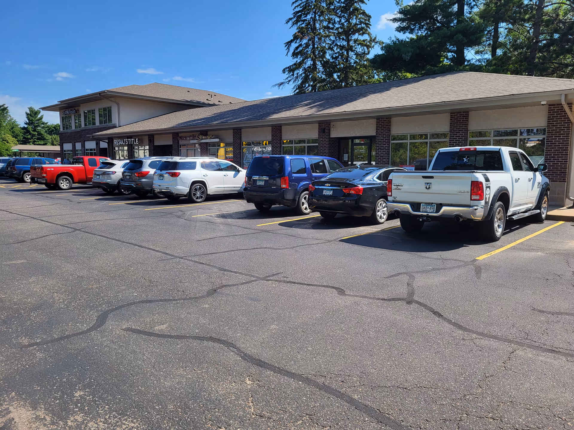Front view of a single-story brick hospice building with a parking lot.