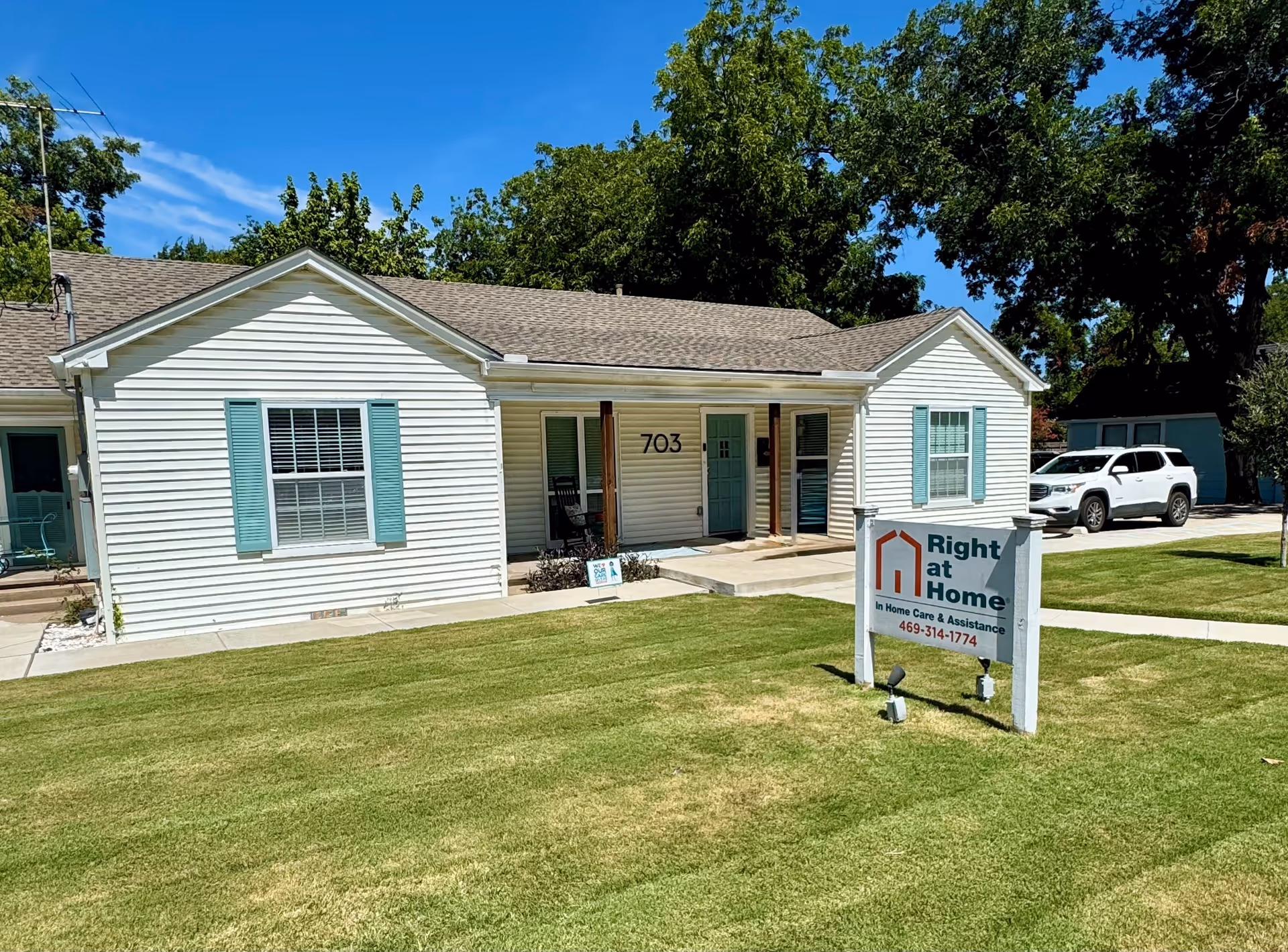White single-story building with light blue shutters and a front sign reading Right at Home