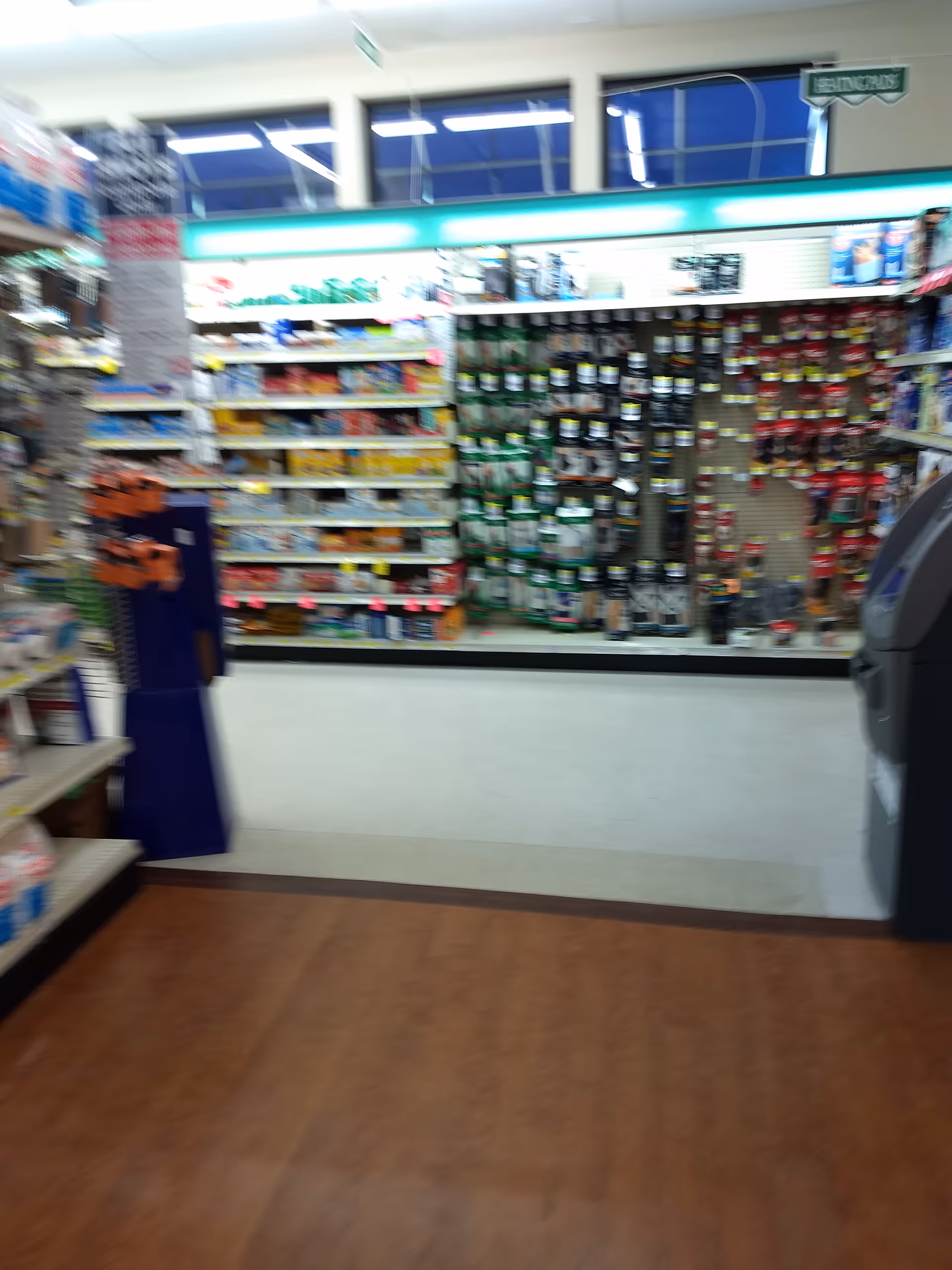 Blurry interior of Discount Drug Mart with shelves stocked with various items.