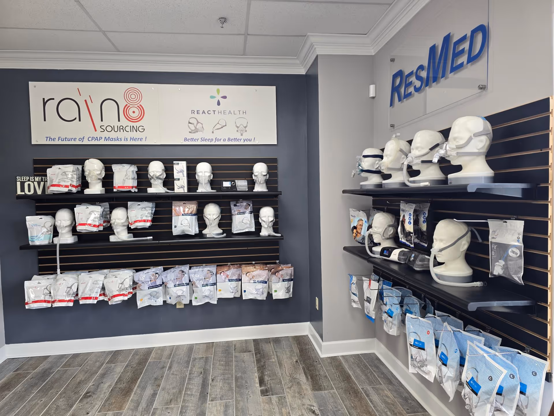 Interior display wall with CPAP masks and mannequin heads on shelves beneath ResMed signage.