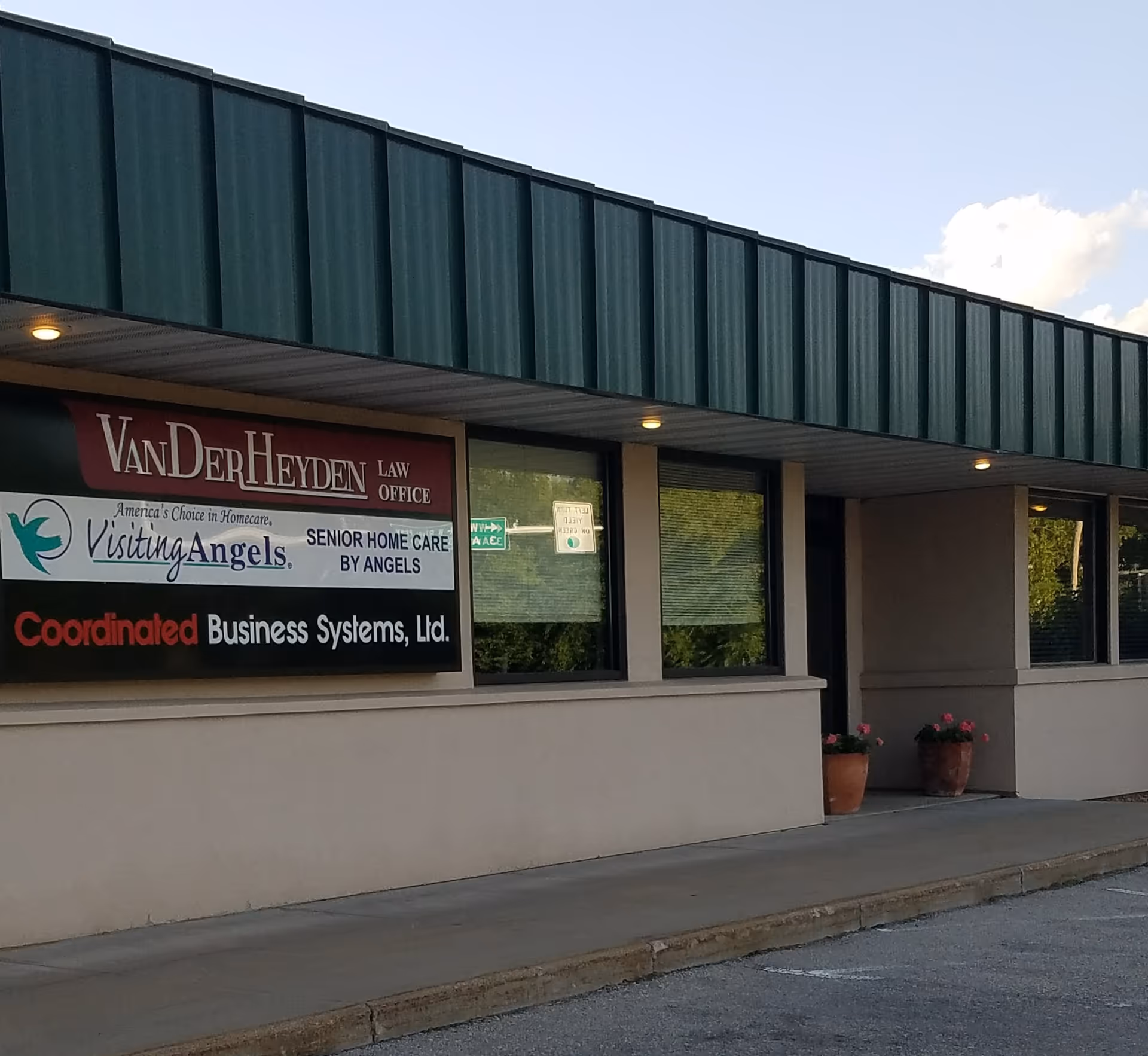 Exterior of a strip mall-style building with Visiting Angels Senior Home Care signs.