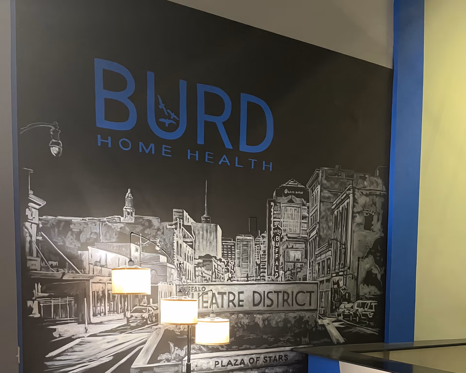 Interior mural wall featuring Burd Home Health logo and theatre district illustration.