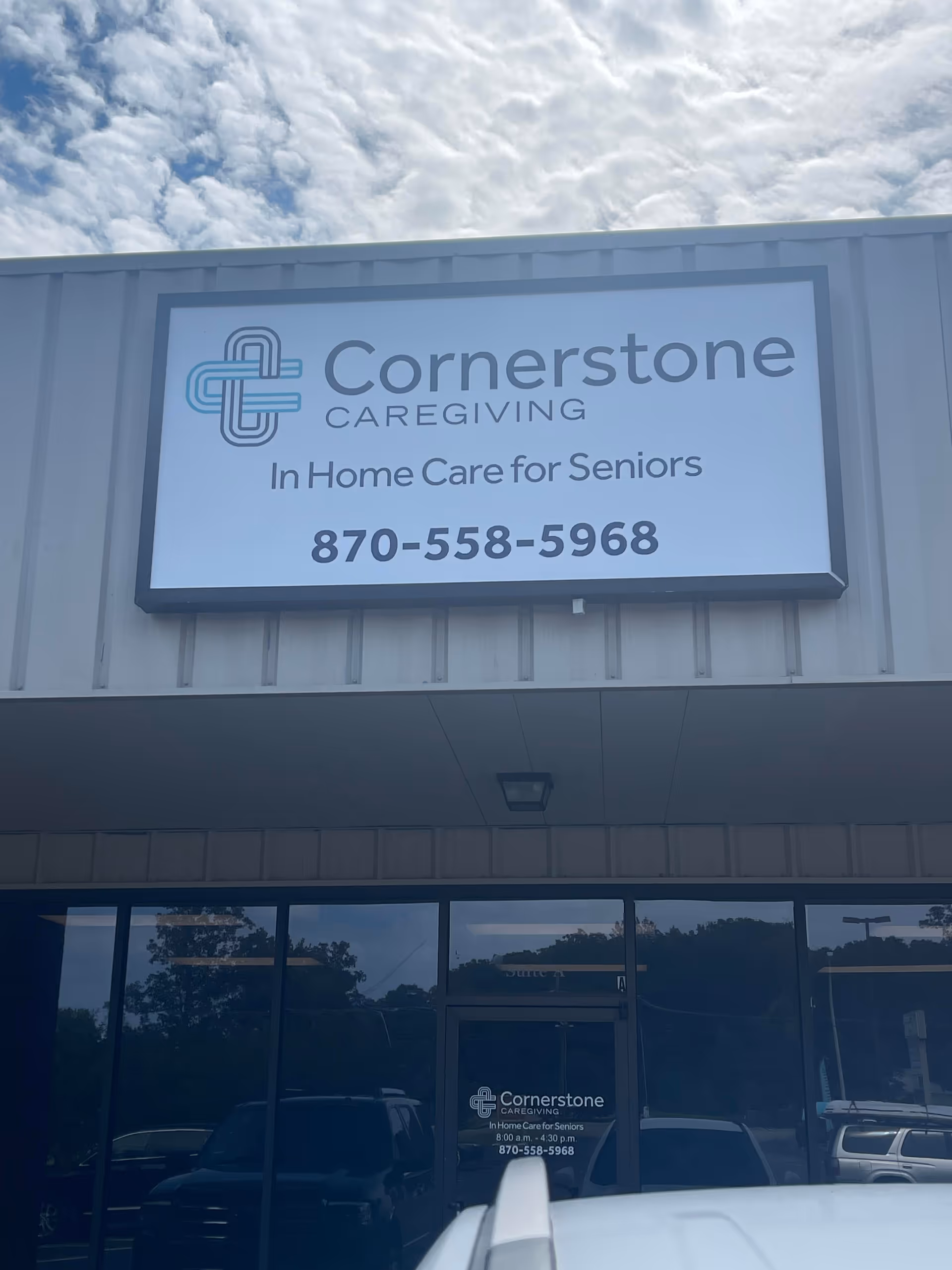 Exterior storefront sign reads Cornerstone Caregiving: In Home Care for Seniors, with phone number.