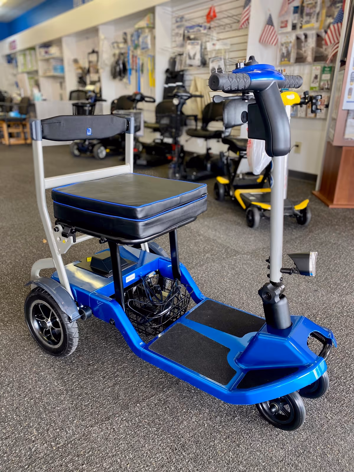 Blue mobility scooter in a showroom with assistive devices on display.
