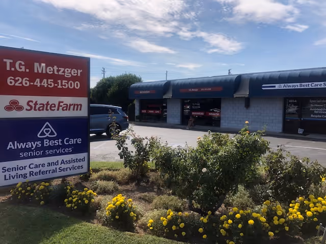 Exterior storefront with Always Best Care signage and landscaped yellow flowers.