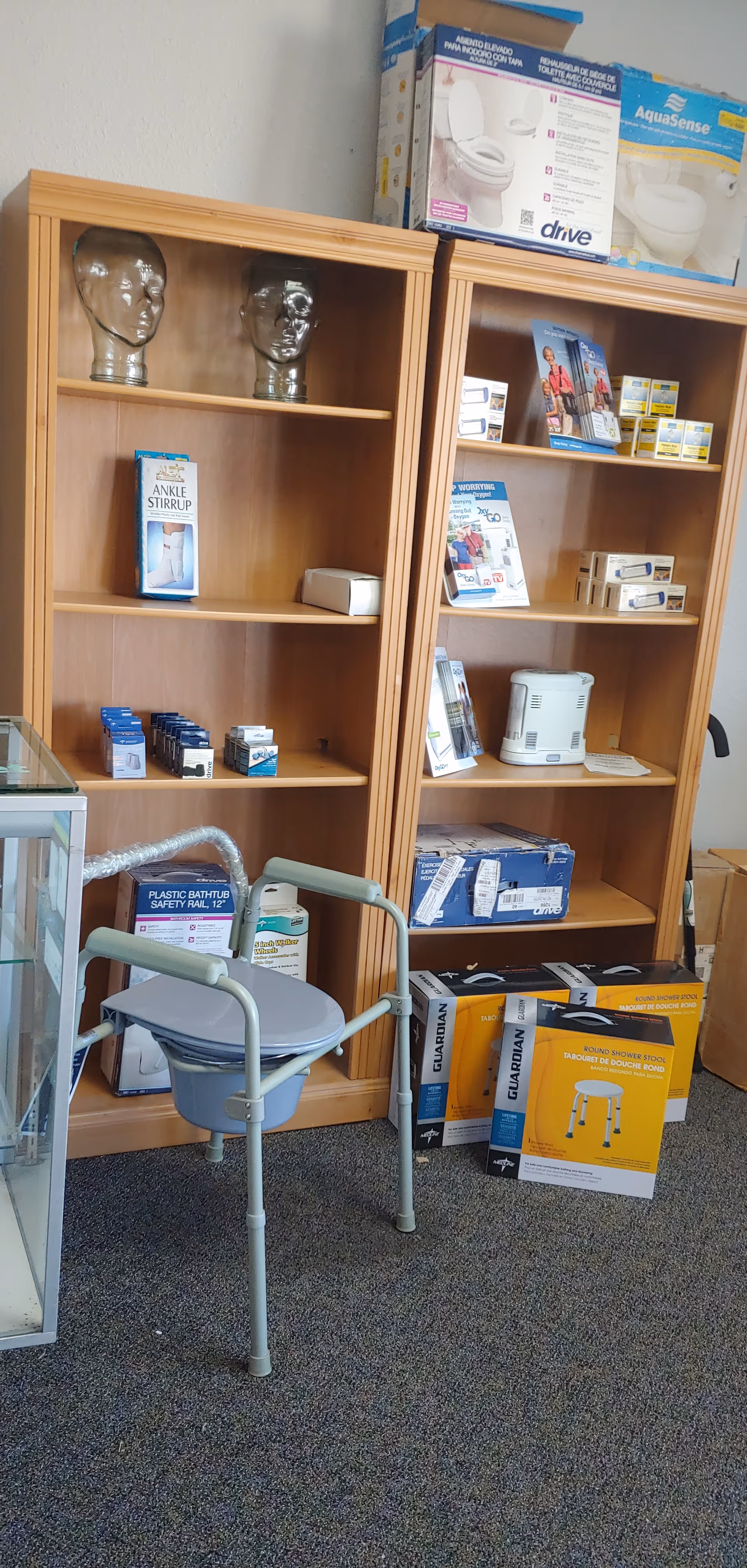 Two tall wooden shelves filled with medical supplies in a clinic corner.