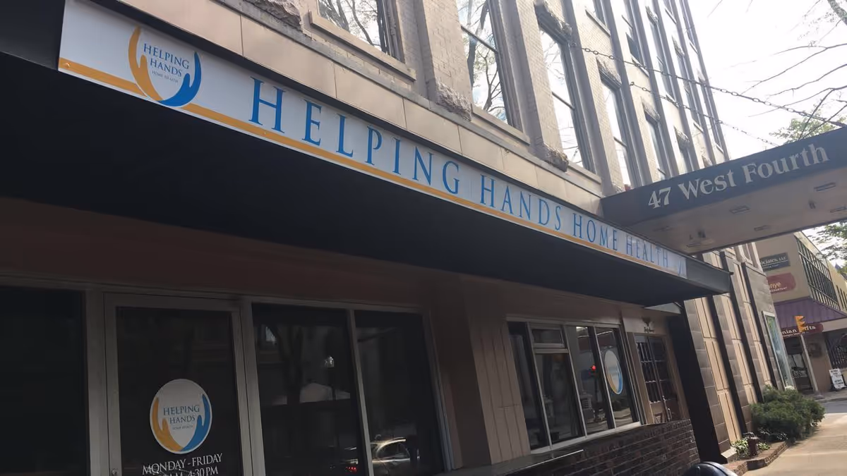 Exterior storefront of Helping Hands Home Health with signage along a city street