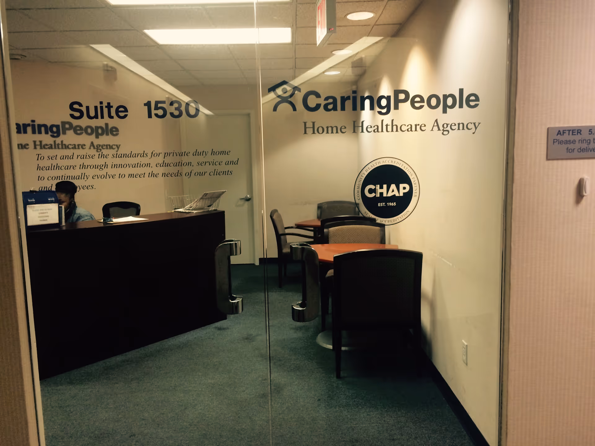Reception area inside CaringPeople Home Healthcare Agency with a receptionist and glass-walled offices.