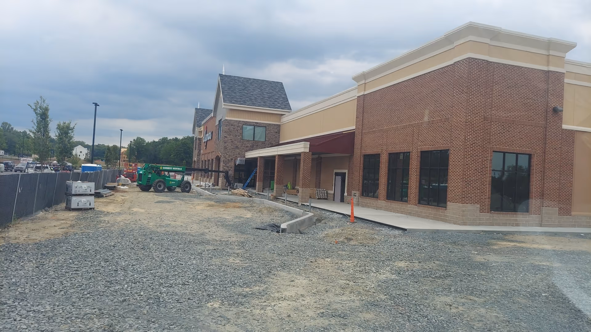 Exterior view of BAYADA Hospice building under construction with a gravel lot and equipment.