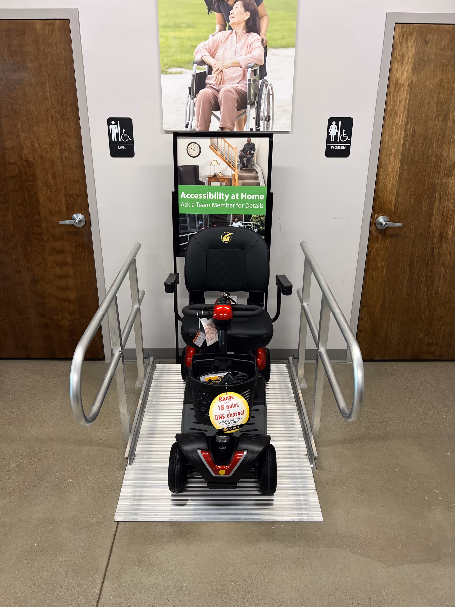 Electric mobility scooter parked in a hallway between restroom doors inside a senior facility.