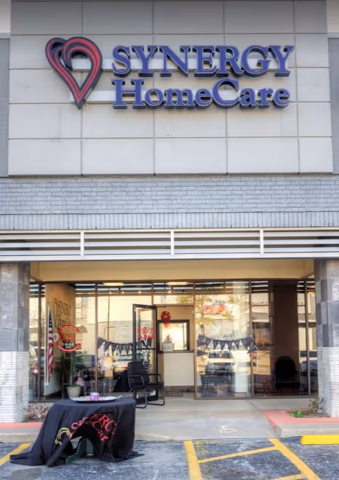 Exterior view of Synergy HomeCare entrance with signage and glass doors.