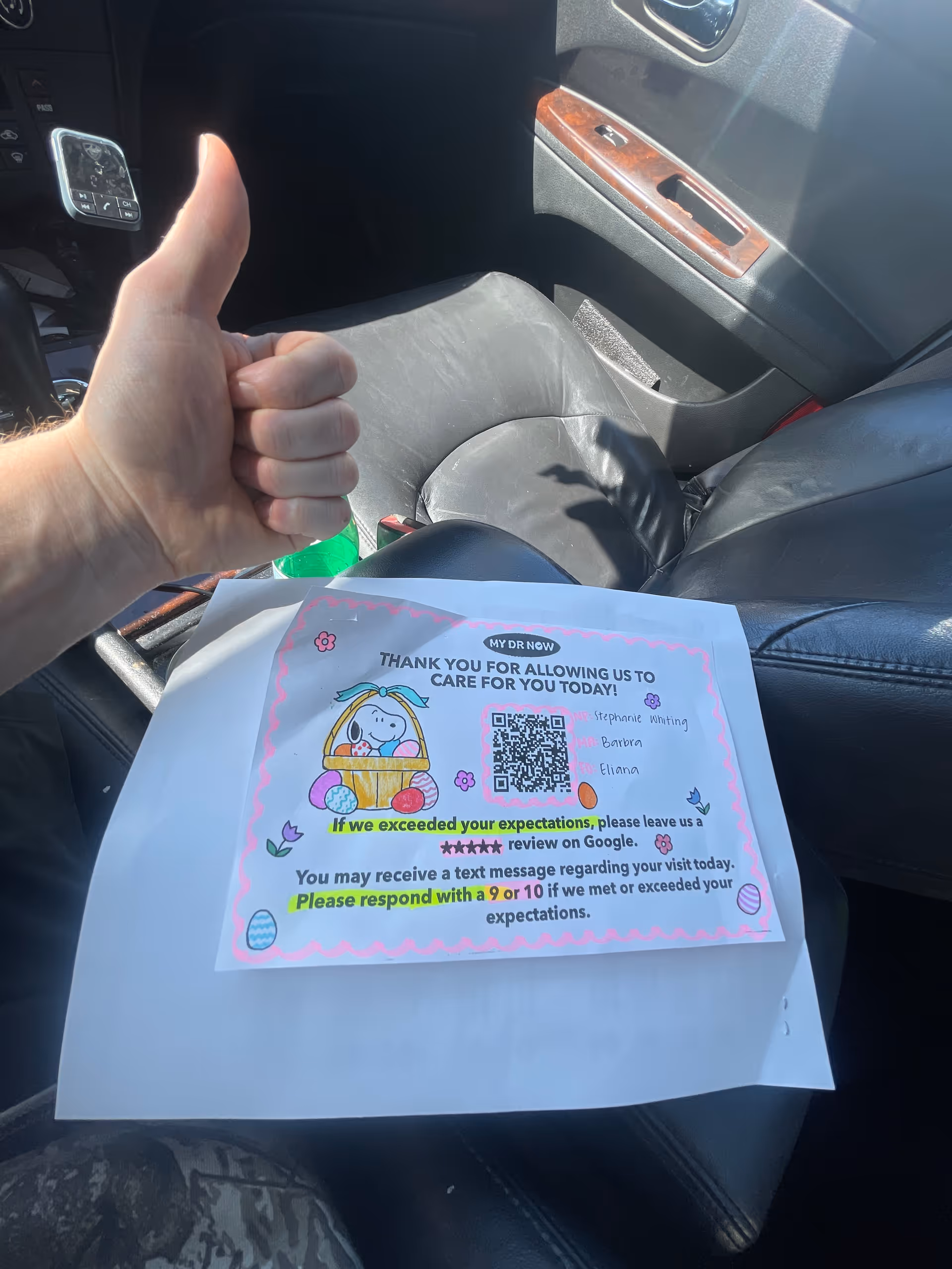 Thumbs-up hand in a car beside a MY DR NOW printed flyer.