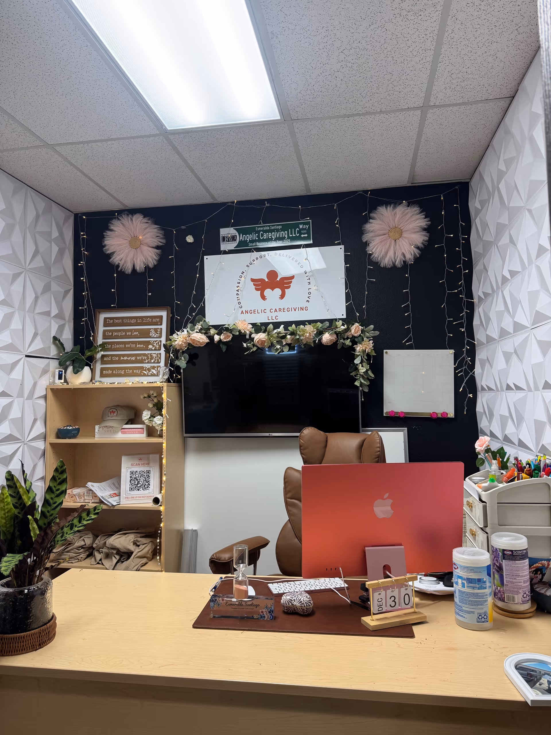 Front desk office area of Angelic Caregiving LLC with a computer and floral decor.