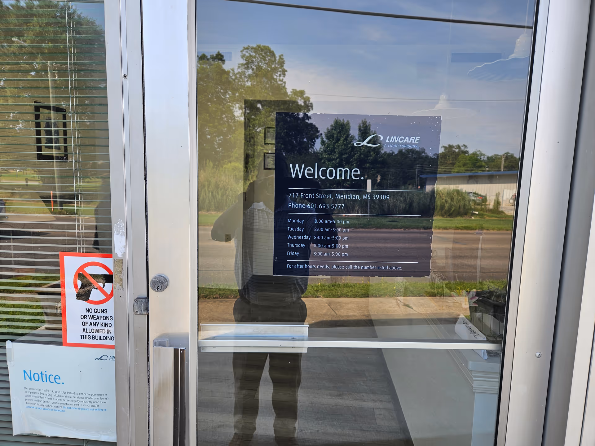 Facility entrance with a large Welcome sign on glass door and posted notices.
