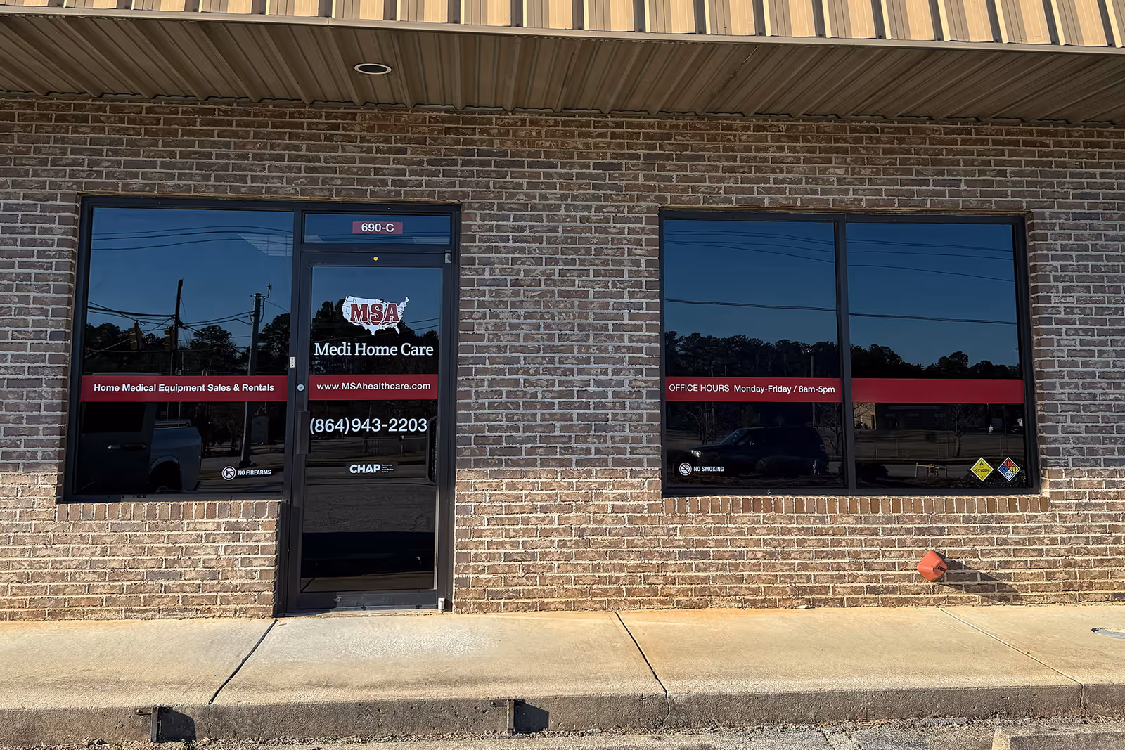 Brick façade of Medi Home Care with glass door and windows displaying signage