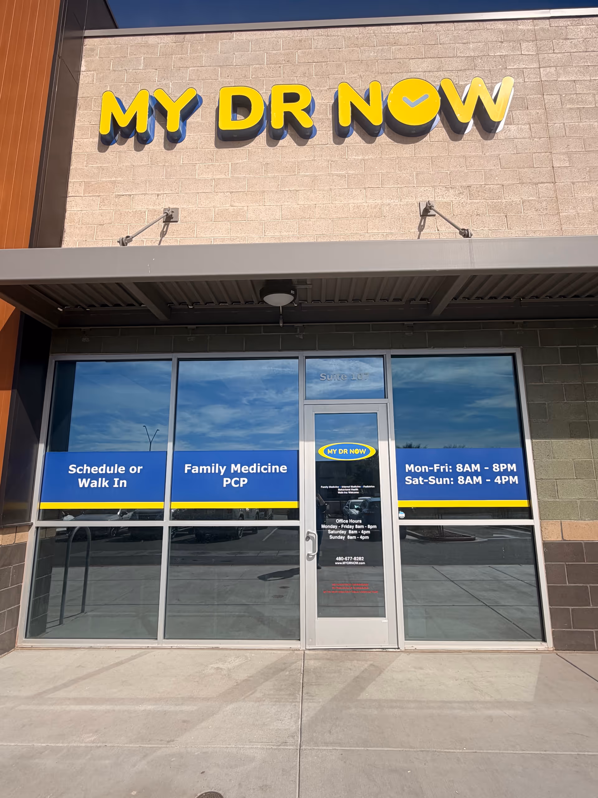 Exterior storefront with MY DR NOW sign, glass doors, and blue window signage.