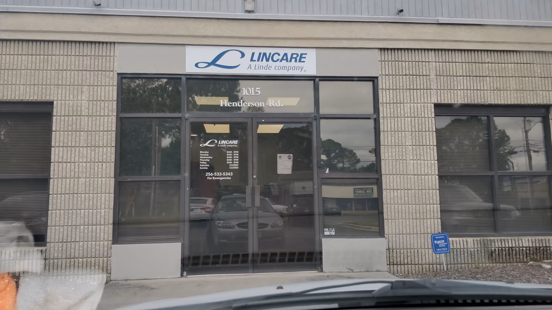 Exterior entrance of Lincare building with glass doors and brick facade.