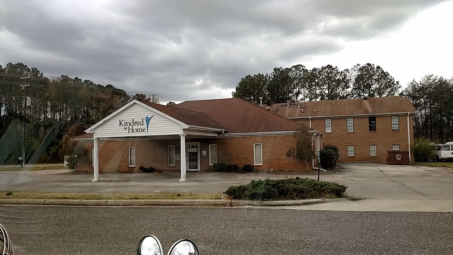 Exterior view of a brick senior care facility with a welcoming front entrance.