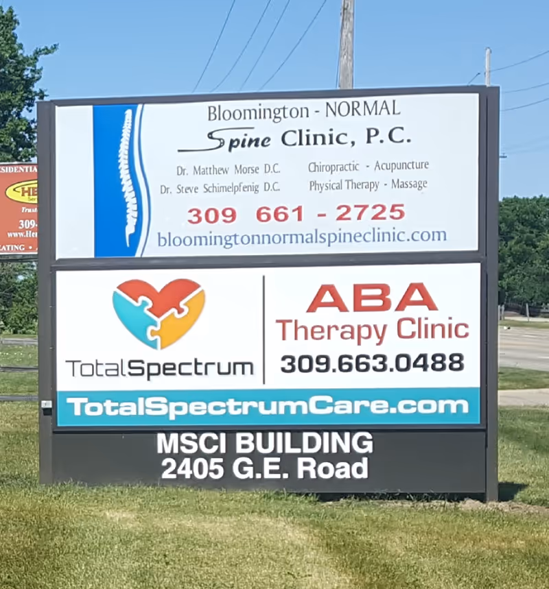 Outdoor multi-panel sign advertising Total Spectrum ABA and ABA Therapy Clinic.