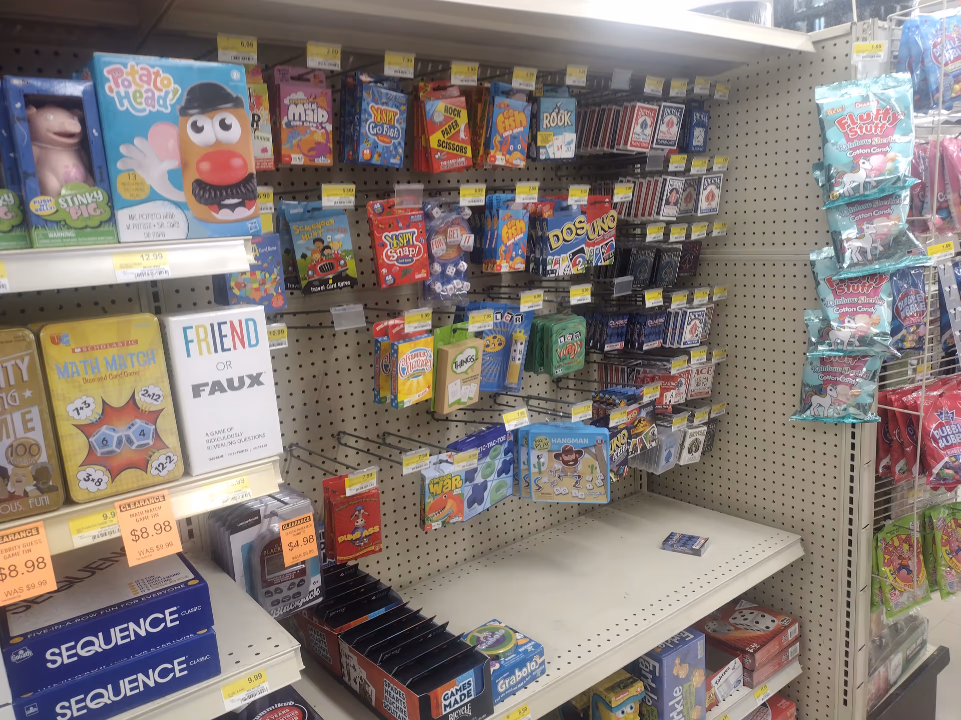 Retail display of toy and game packaging on pegboard shelves in a store aisle.