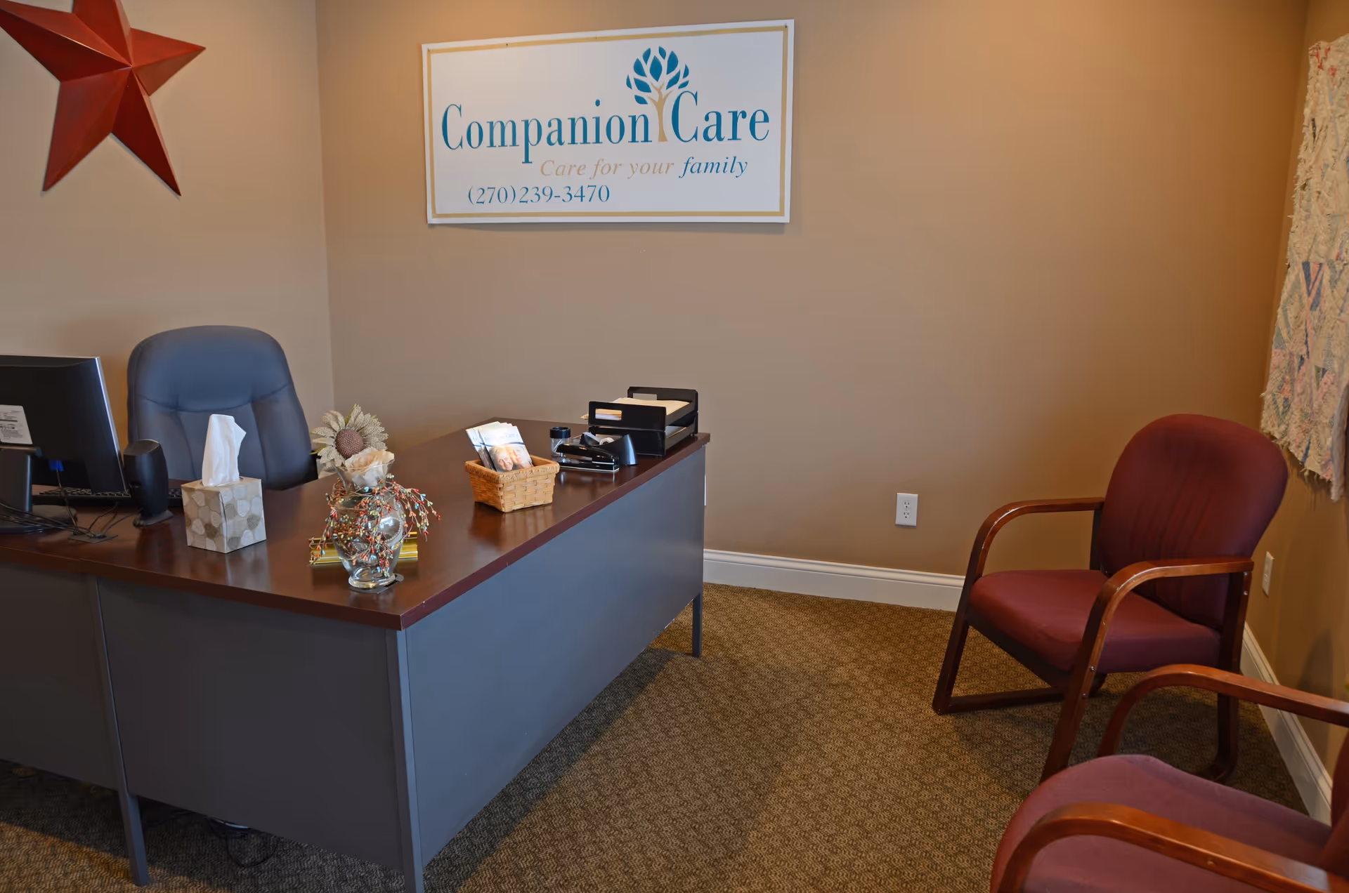 Reception desk in a lobby with a Companion Care sign and burgundy chairs.