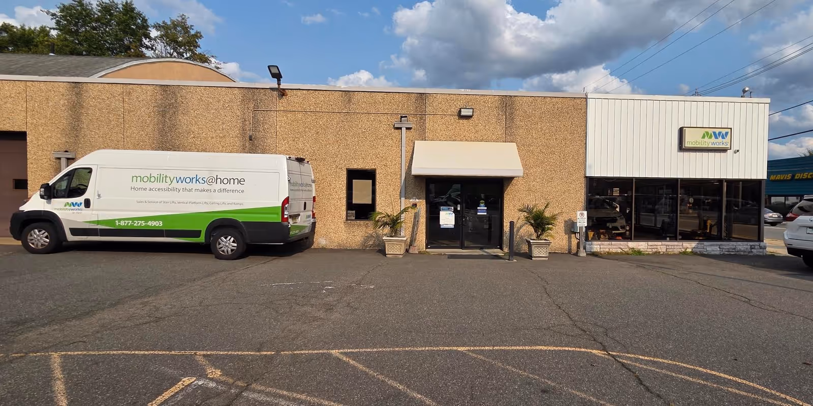 Exterior view of MobilityWorks building with a white and green service van parked outside.