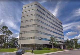 Exterior view of a modern, curved, glass-front, multi-story building.