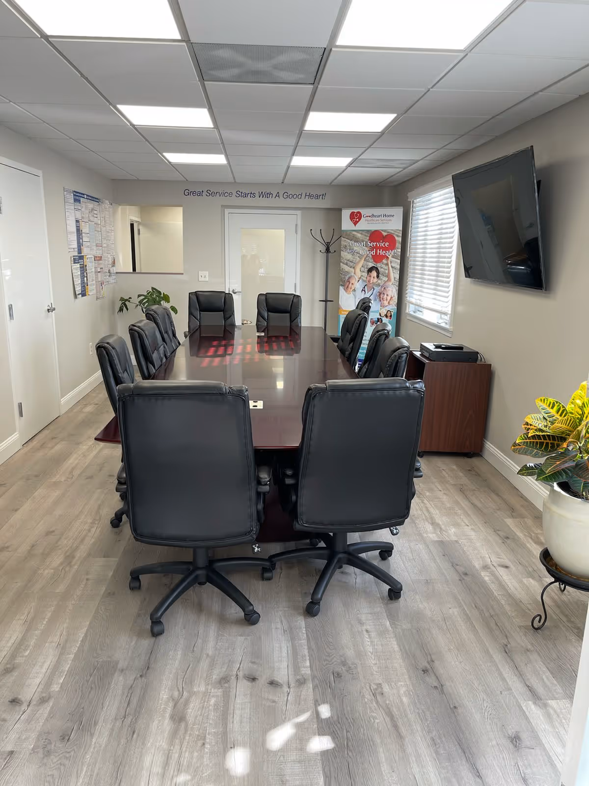 Long conference table with black chairs in a bright indoor meeting room.