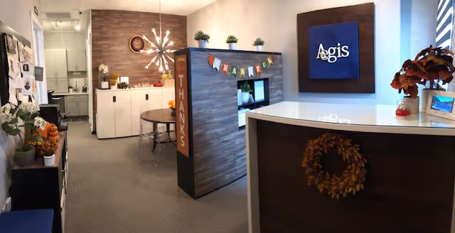 Reception lobby of Aegis Senior Care with curved front desk and decor.