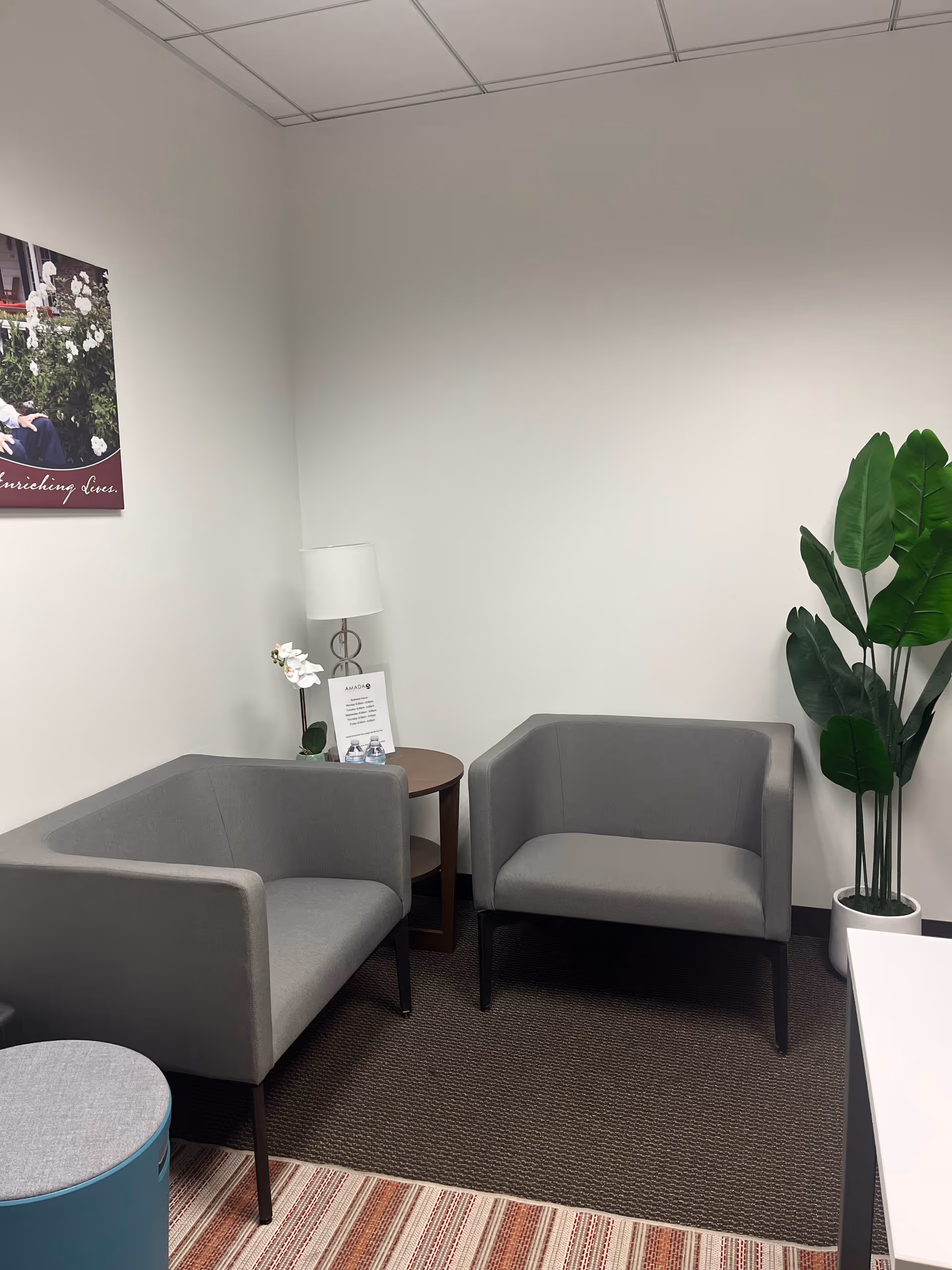 Two gray armchairs surround a small table in a quiet waiting lounge.