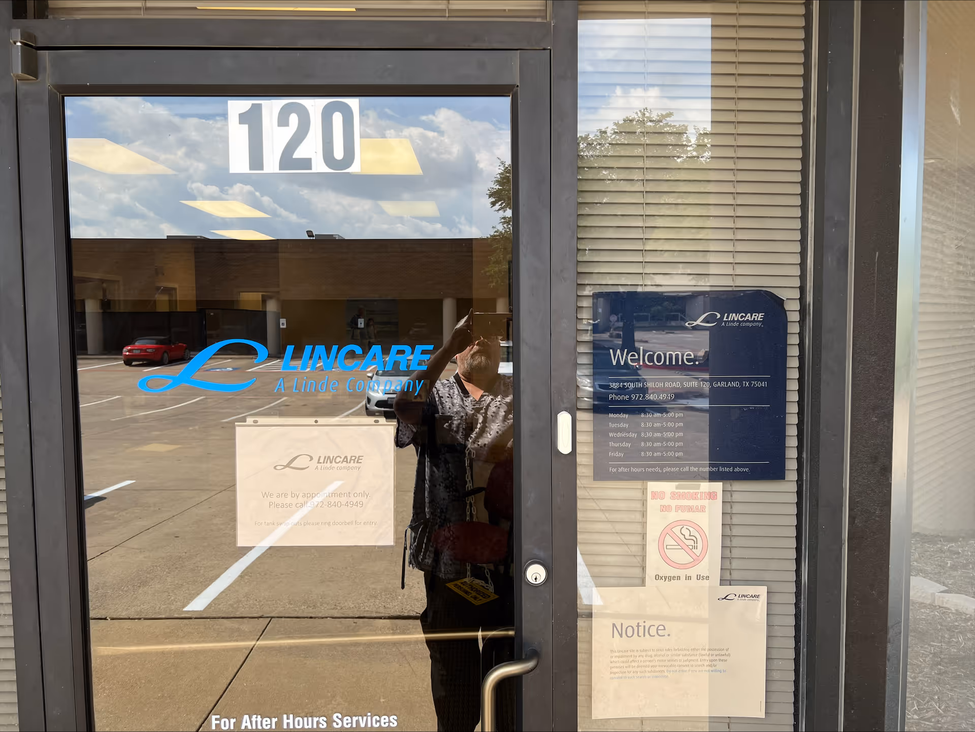 Glass entrance door showing Lincare signage and a welcome board with parking lot reflection.