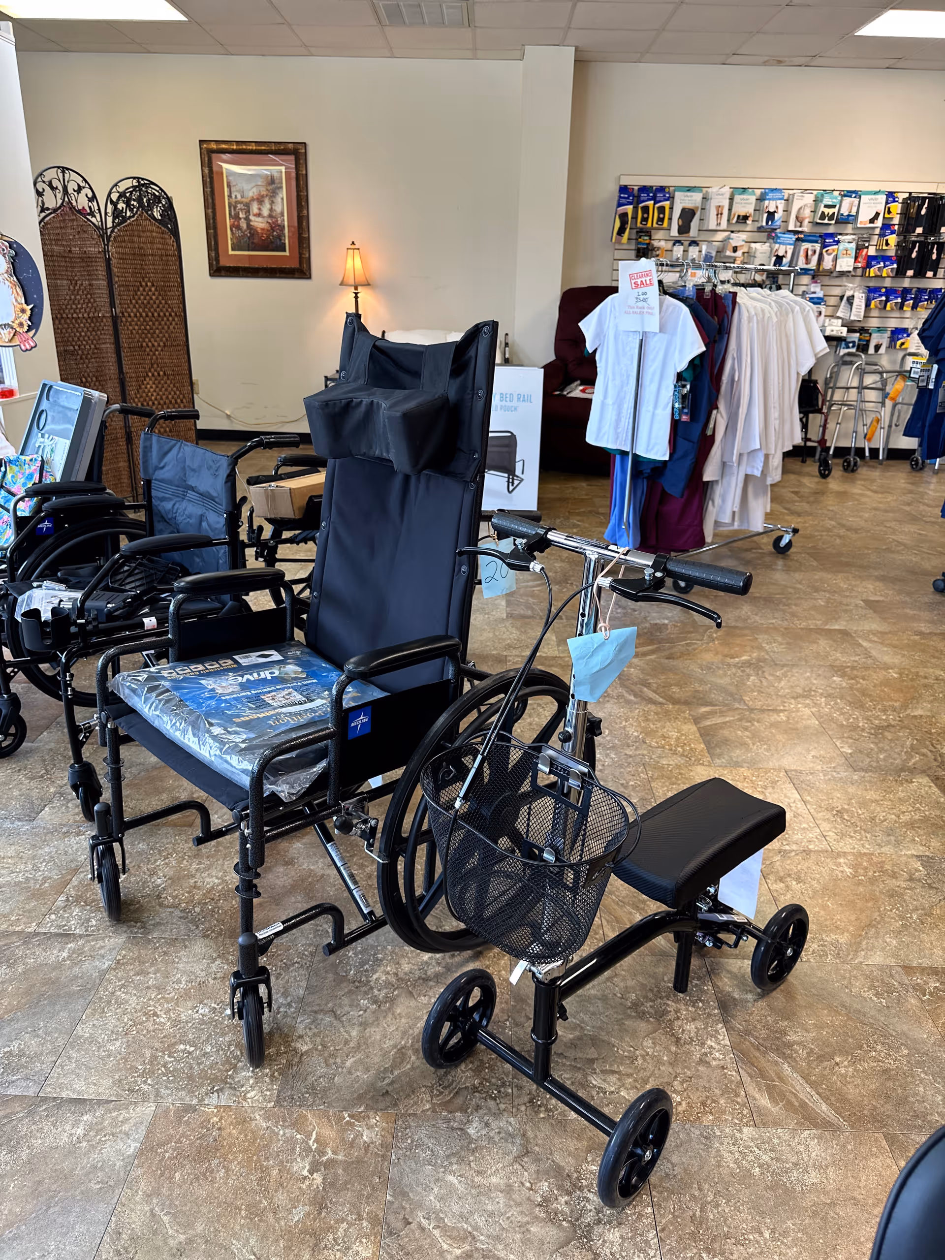 Interior showroom displaying wheelchairs, walkers, and medical accessories near clothing racks.