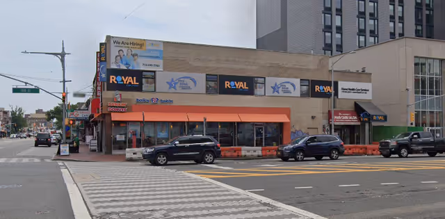 Exterior storefront building with orange awnings and Royal Care signage along a city street.