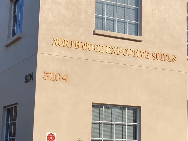 Exterior view of a beige building with Northwood Executive Suites signage and numbers.