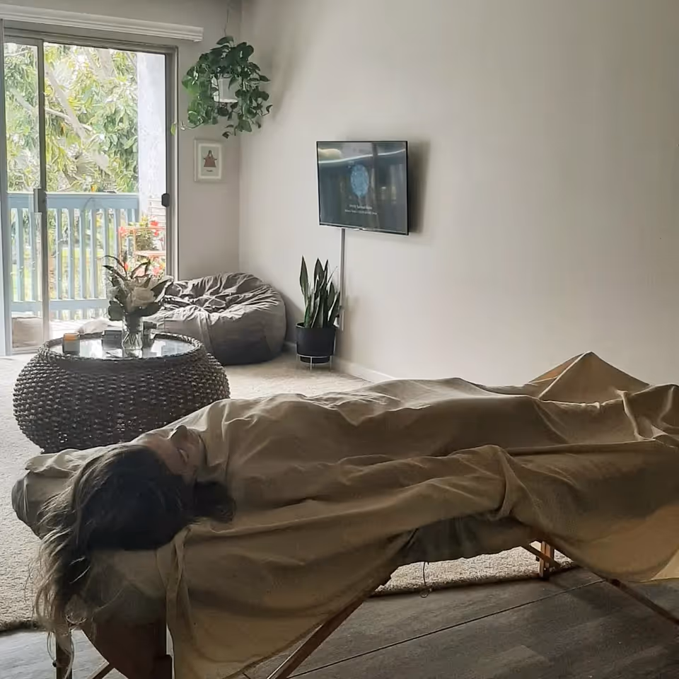 Resident receiving mobile massage on a table in a bright living room.