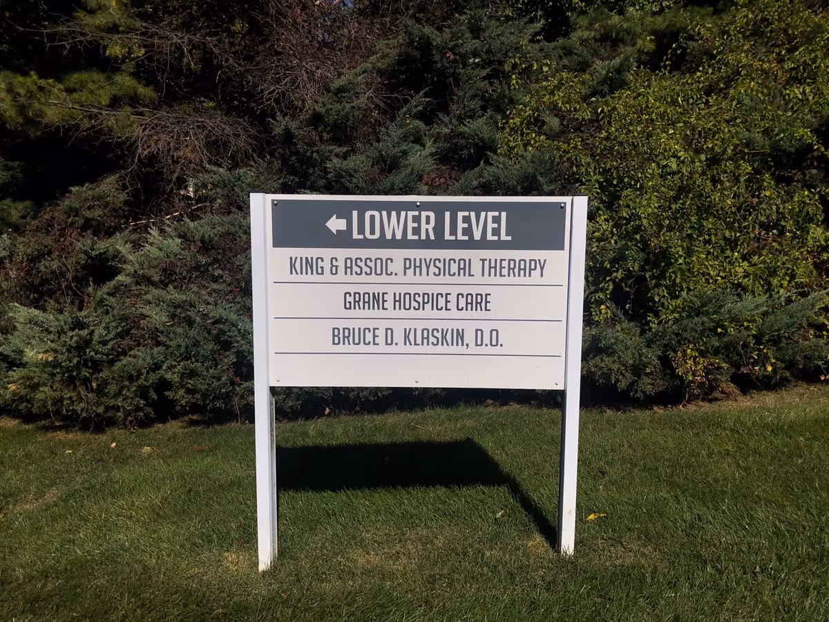 Outdoor lawn sign directing to the lower level Grane Hospice Care and therapy offices.