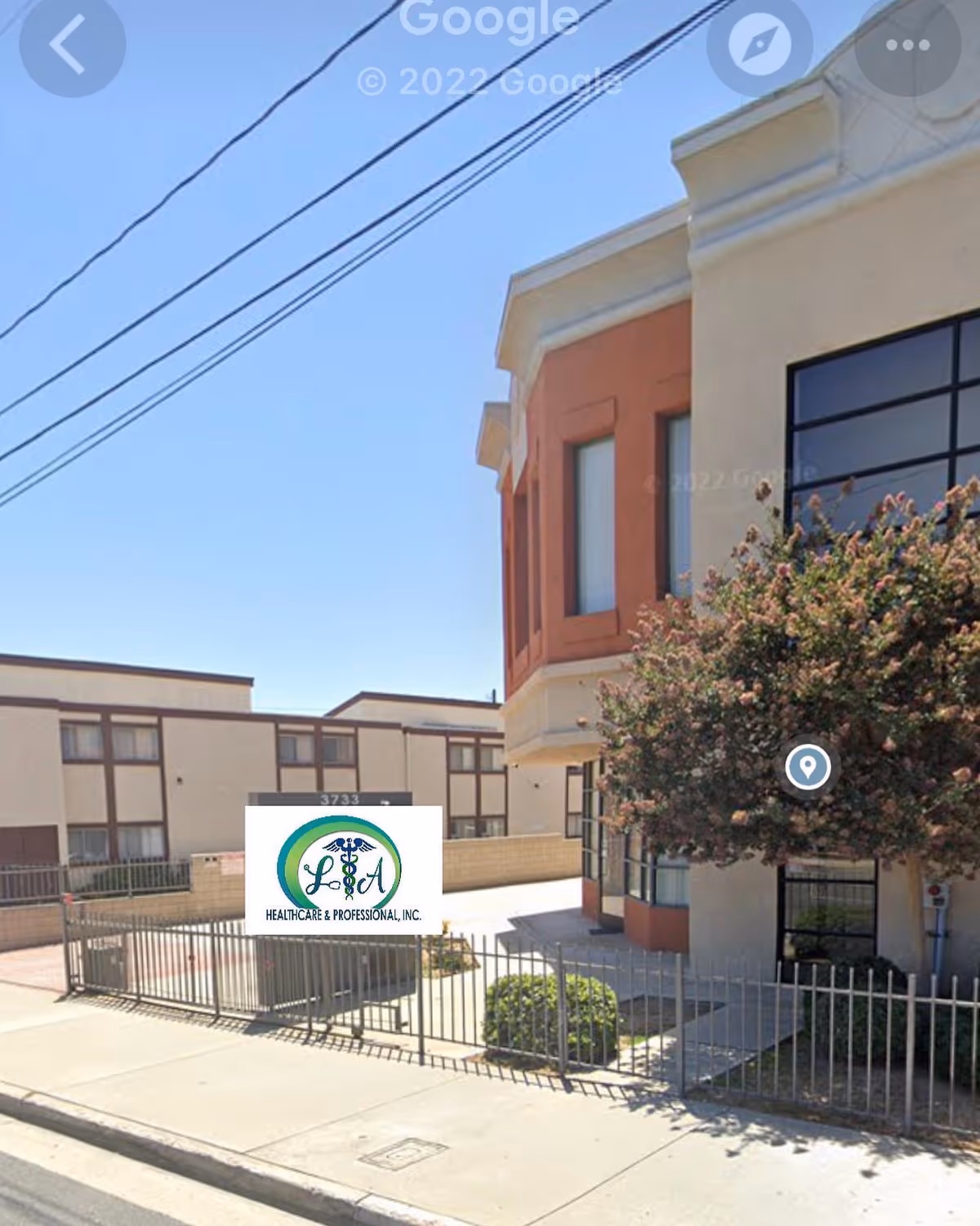 Exterior view of LA Healthcare & Professional, Inc. building with sign and trees.